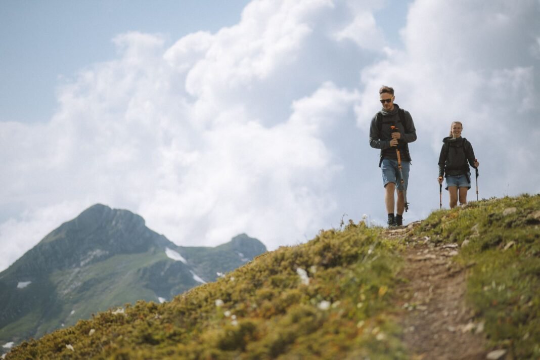 Building Resilience as a Nigerian: 7 Growth Mindset Habits Two hikers climbing a green mountain ridge, a metaphor for building resilience