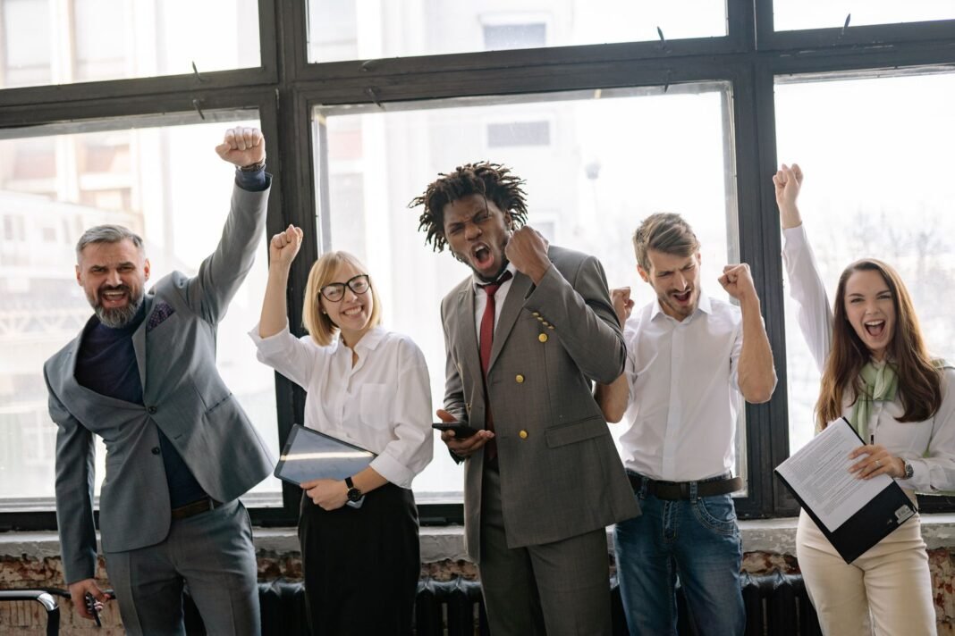 7 Career Comeback Lessons From Nigerians Who Reinvented Themselves A group of professionals smiling together after a career win