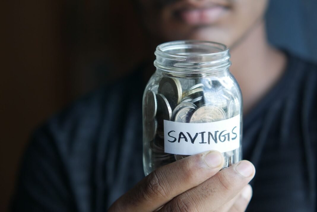 Money Management for Nigerians: 8 Rules to Build Wealth Coins in a jar labelled savings, representing consistent money habits