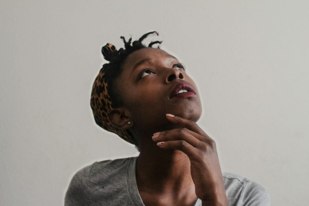 Your Mates Are Buying Cars and Japa-ing. Here’s How to Stop Comparing Thoughtful young Black woman looking upwards, reflecting on comparison and self-worth