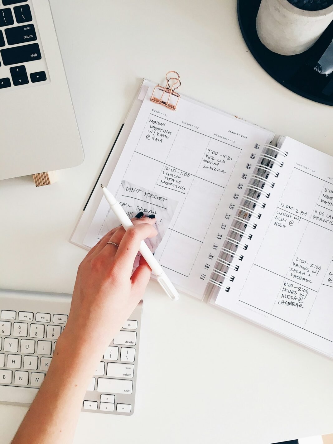 Hand writing goals in a notepad on a desk