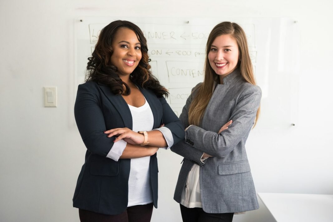Two confident professional women standing in an office