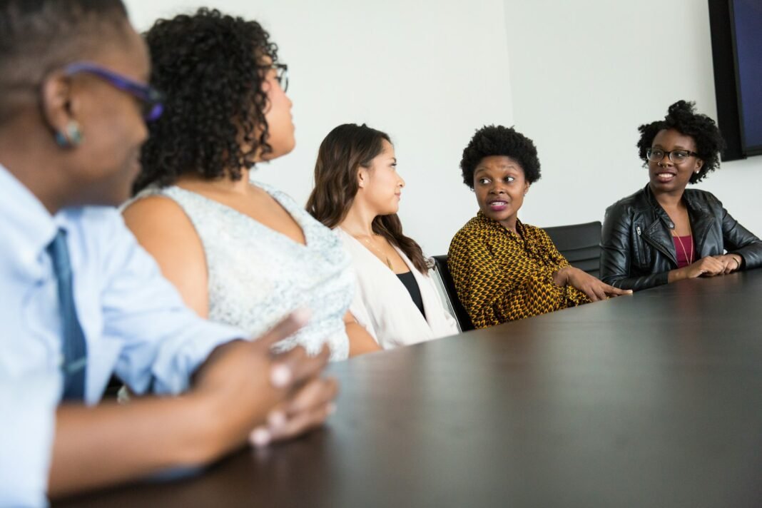 Just Became a Manager? Here’s How to Lead, Even When Your Team Is Older Black woman manager leading a team discussion around a meeting table