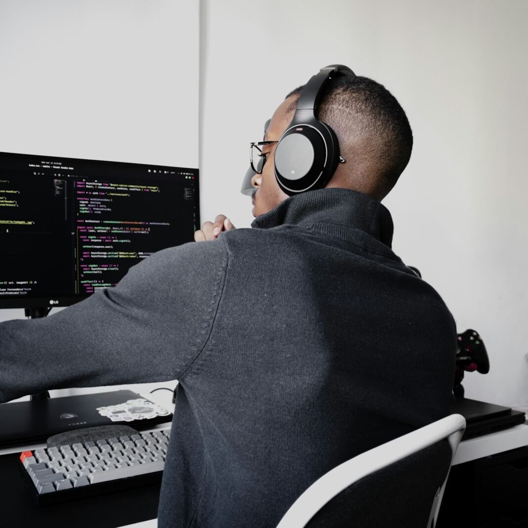 High-Income Digital Skills Worth Learning (and How to Start) Developer wearing headphones and writing code on multiple screens