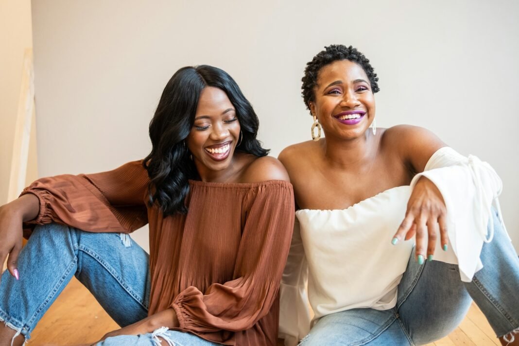 Two women sitting together, laughing and connecting in conversation