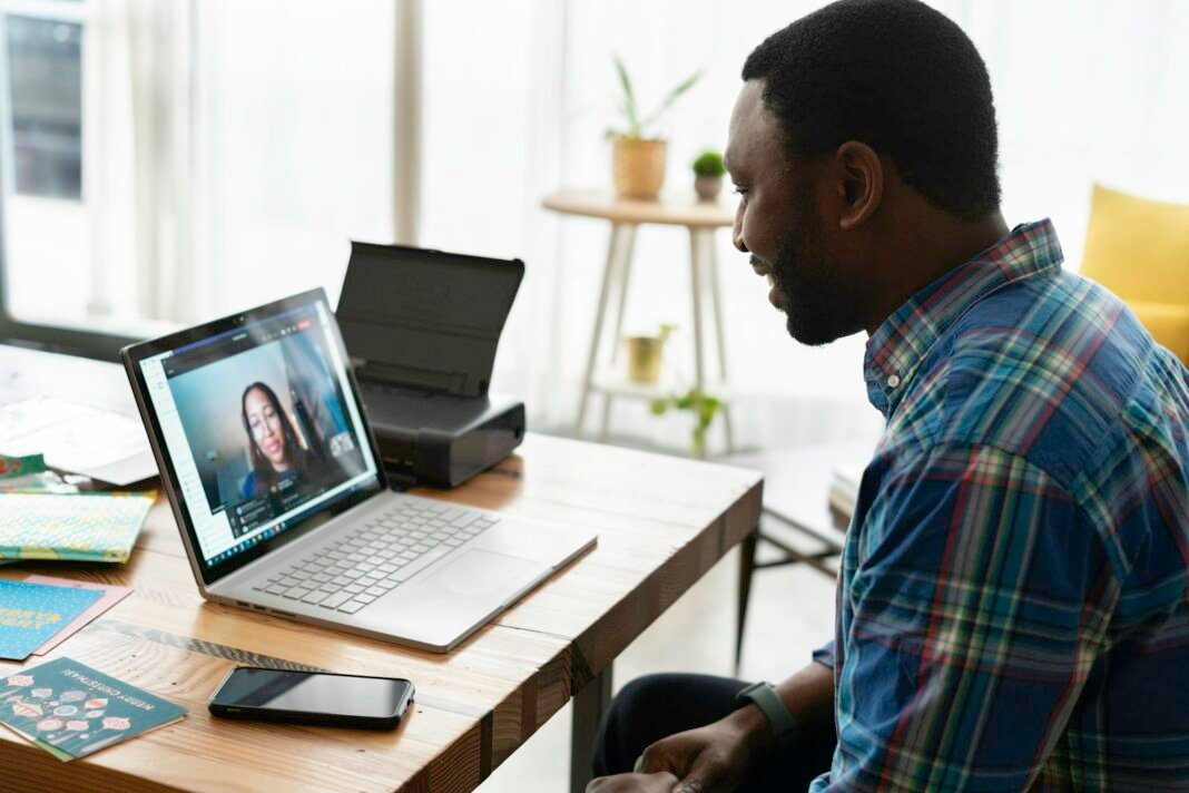 Black man on a video call on his laptop at home, taking part in a remote job interview