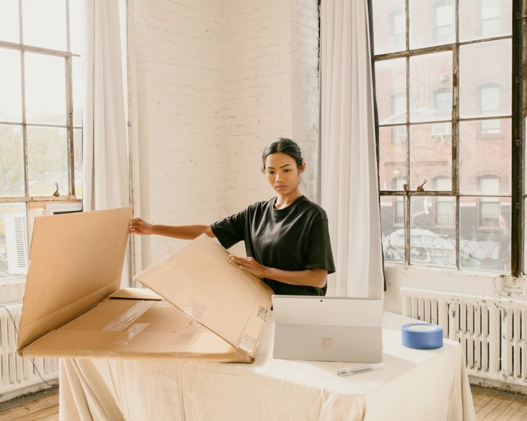 Woman packing customer orders in boxes for her side business