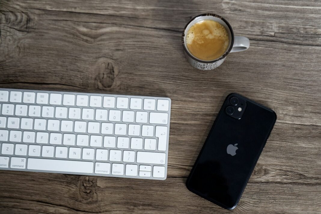 Desk with a keyboard, a smartphone and a cup of coffee, a common setting for procrastination