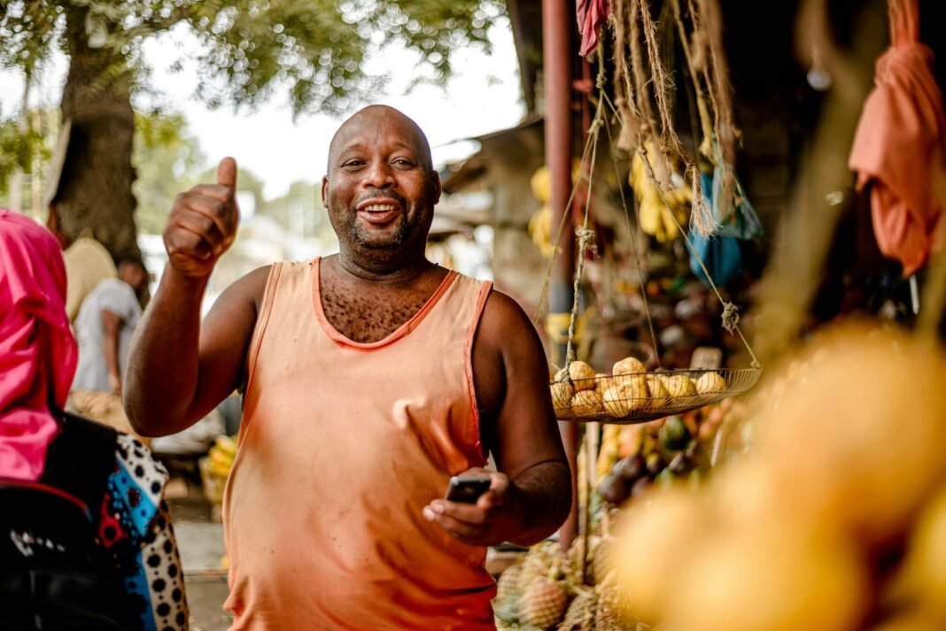 How to Validate a Business Idea Before You Spend Money Smiling market vendor at a fruit stall giving a thumbs up