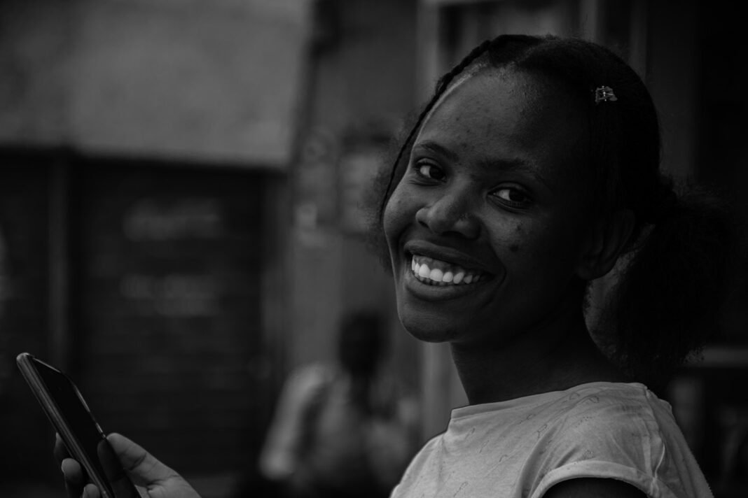 Social Media and Mental Health: How to Build a Healthier Relationship With Your Phone Young African woman smiling while using her smartphone