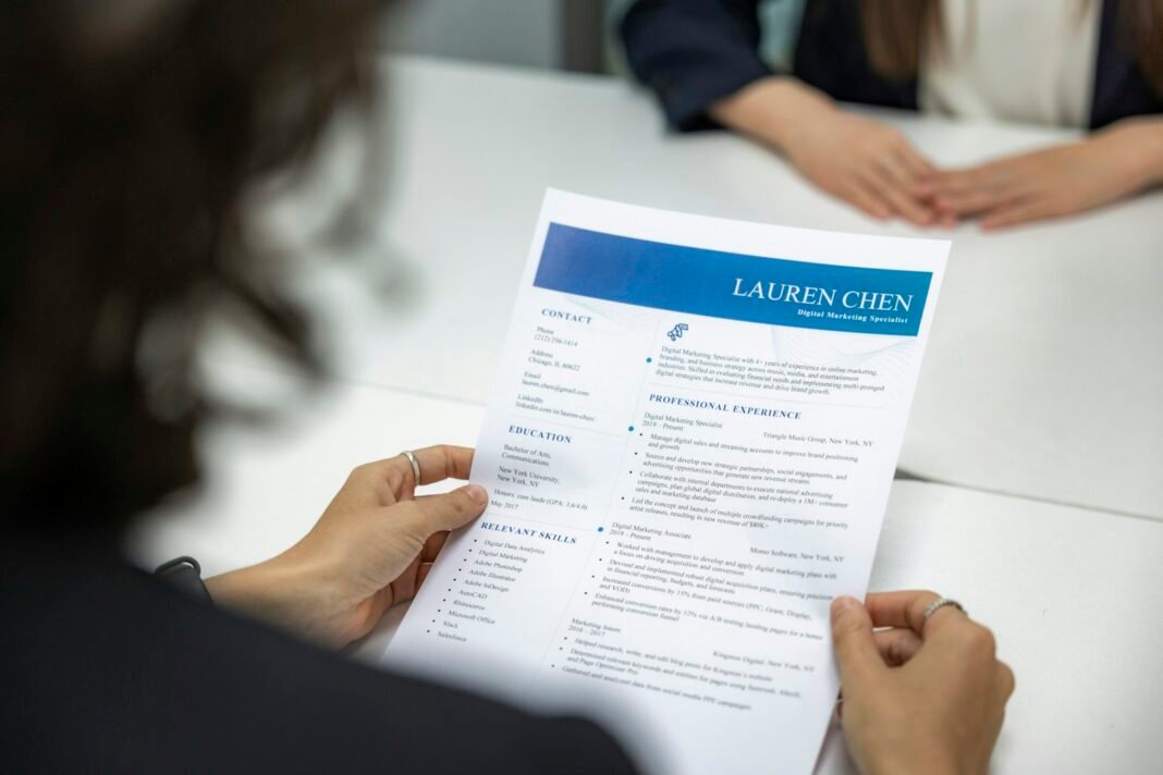 How to Write a CV That Gets Interviews in Nigeria Person reviewing a printed CV at a table
