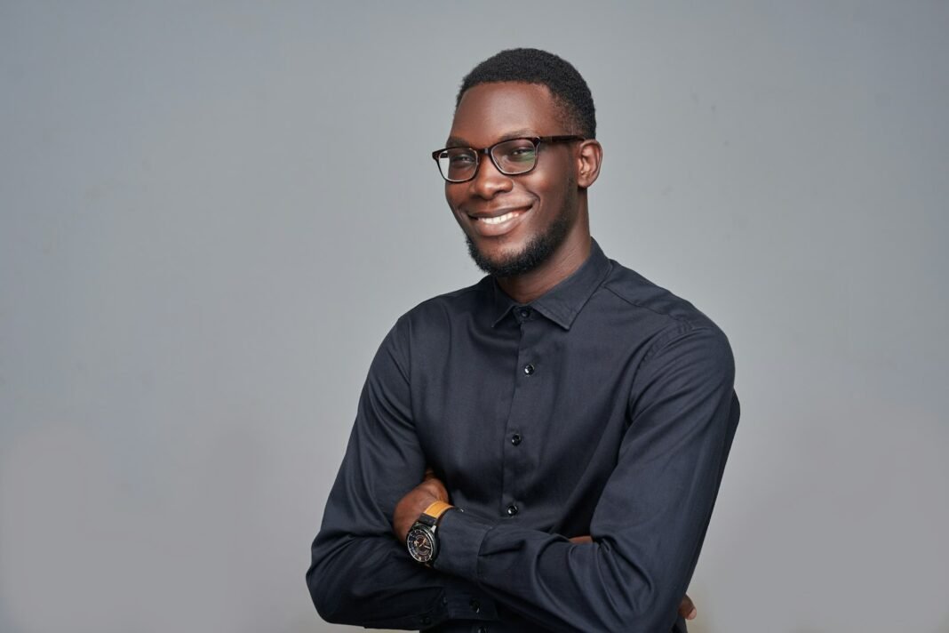 NYSC on ₦77,000: How to Budget, Save and Build Your Career During Service Year Smiling young Nigerian professional in a black shirt and glasses